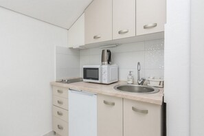 A compact kitchen with a microwave, a coffee maker, a sink, and a dishwasher. - Pool Apartment Sea 2, Privlaka, Croatia (Privlaka)