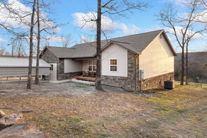 A two-story house with a stone foundation and a sloped roof.