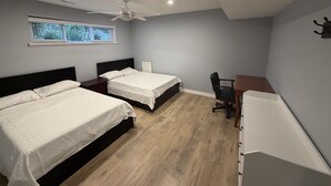 A bedroom with two beds, a ceiling fan, a window with blinds, a desk, and a chair. - Vancouver in Style - Newly listed renovated home in Delta's Sunshine Hills (Delta)