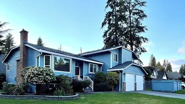 A two-story house with a garage, a front yard, and a large tree. - Vancouver in Style - Newly listed renovated home in Delta's Sunshine Hills (Delta)