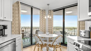 Eine moderne Küche mit Essbereich, großen Fenstern und Blick auf die Stadt.