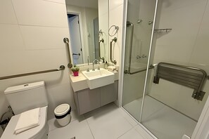 A bathroom with a toilet, sink, mirror, and glass shower enclosure. - Dommy (São Paulo)