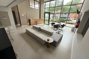 Ein modernes Interieur mit einer Eckcouch, einem kleinen runden Tisch und einem Essbereich mit Stühlen.