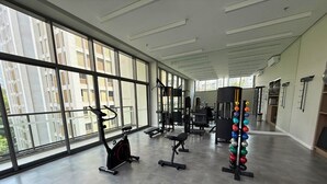 A modern gym with large windows, exercise equipment, and a grey floor. - Dommy (São Paulo)