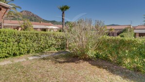 Zona residencial con casas, una palmera y una montaña al fondo.