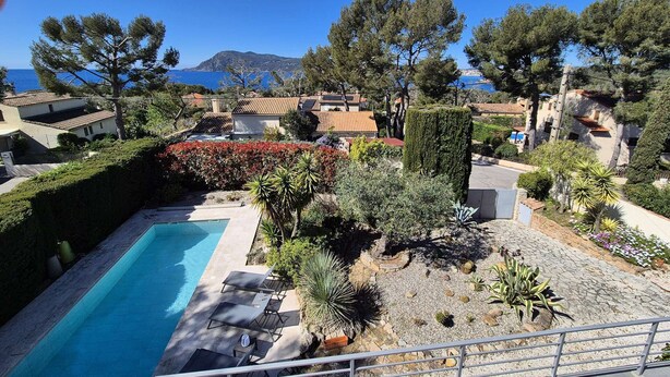 A pool with lounge chairs, a well-maintained garden, and a view of the sea and mountains. - Beautiful villa, sea view, swimming pool, WIFI (ST MANDRIER SUR MER)