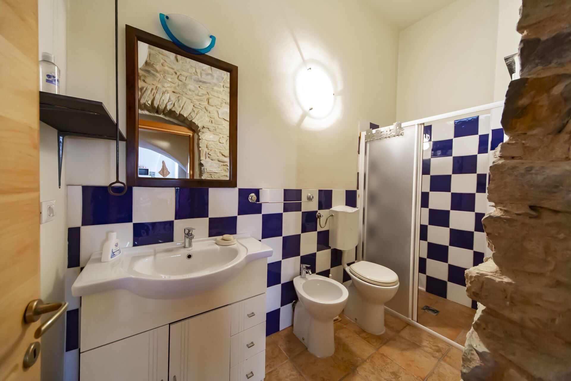 Een badkamer met een wastafel, toilet, douche en een bidet.