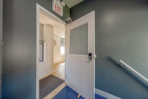 Ein Flur mit einer Tür, einem blauen Teppich, einer weißen Tür und einer Wand mit dem Schild 'EXIT'.