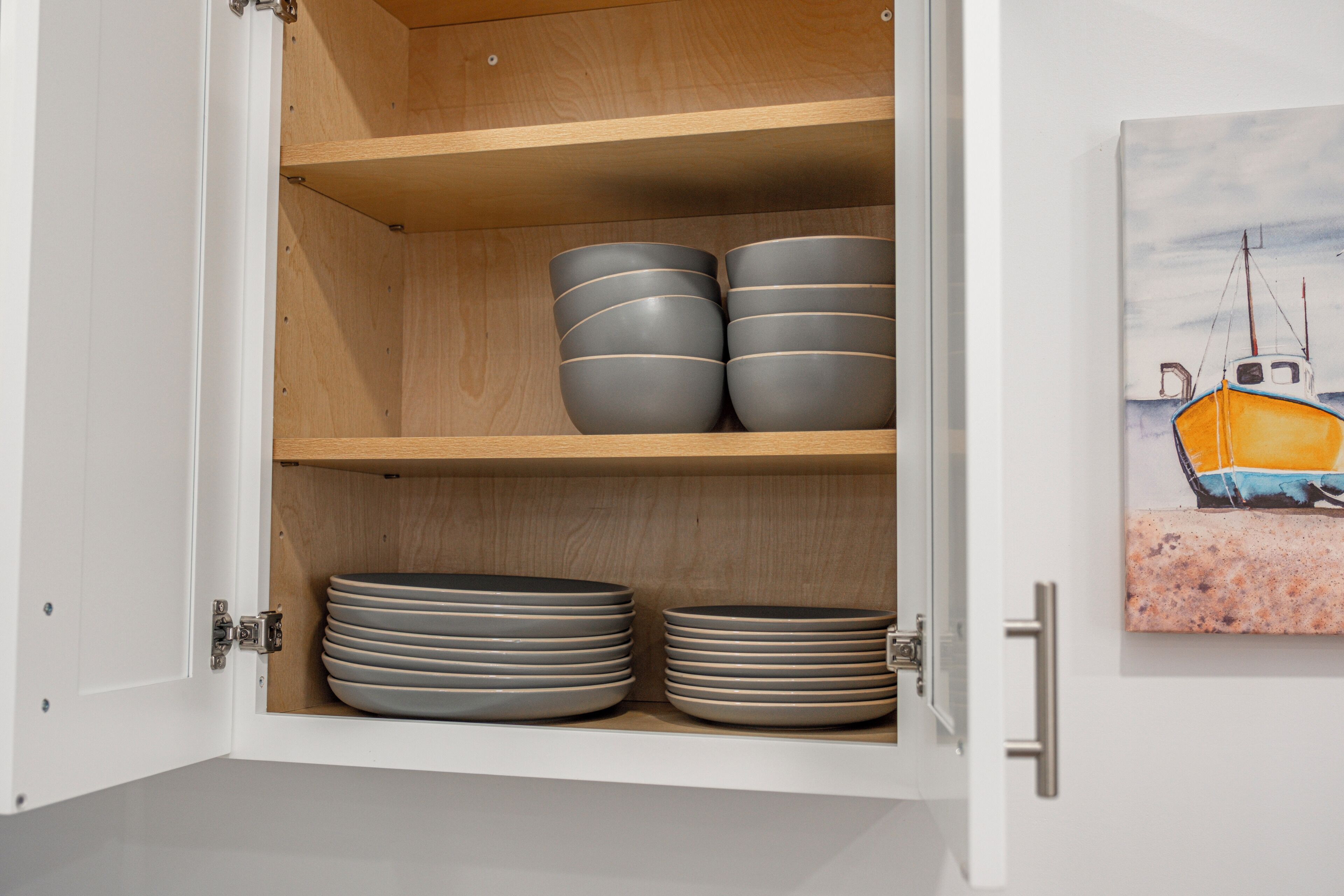 A cabinet with shelves holding plates and bowls.