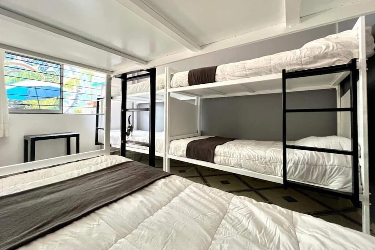 A room with bunk beds, a window with a view, and a small table.