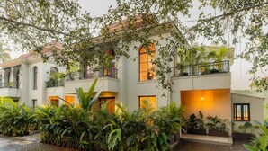A multi-story building with balconies, a courtyard with plants, and a tiled floor.