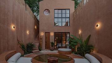 A modern building with a central courtyard, a circular water feature, and a staircase leading to an upper level.
