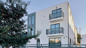 A modern two-story building with balconies, a gated entrance, and a clear sky. - USC Private Suite & Bath/Long-Term/Utilities, Wi-Fi & Laundry Incl. 4m to campus (Los Angeles)