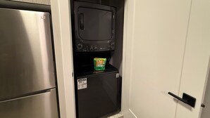 Cocina compacta con microondas integrado, un refrigerador pequeño y una puerta con manija.