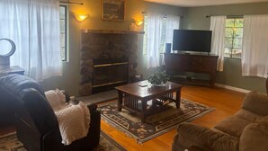 A living room with a fireplace, a television, and a sofa.