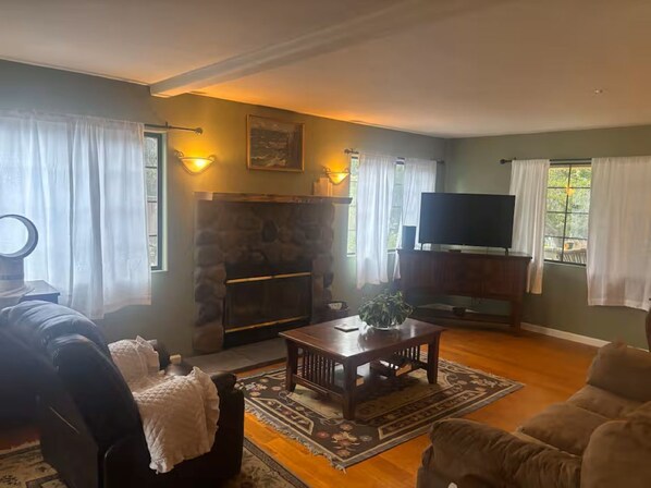 A living room with a fireplace, a television, and a sofa.