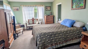 Ein Schlafzimmer mit einem großen Bett, einem Schminktisch, einem Sessel und einem Schreibtisch.