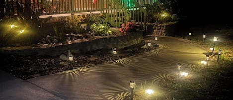 A house with a porch, a flag, and outdoor lighting.