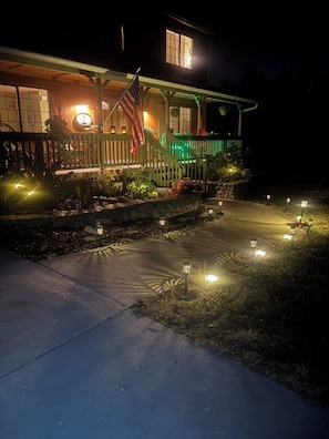 A house with a porch, a flag, and outdoor lighting. - Rustic Canyon Retreat (Salinas)