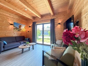 Un intérieur en bois avec un canapé, une table basse et un téléviseur.