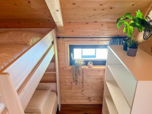 A wooden cabin room with bunk beds, a small window, and a shelf with plants. - Lovely holiday home on park near ski resort (Rattendorf)