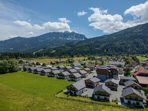 Un quartier résidentiel avec des maisons, un ciel dégagé et des montagnes en arrière-plan.