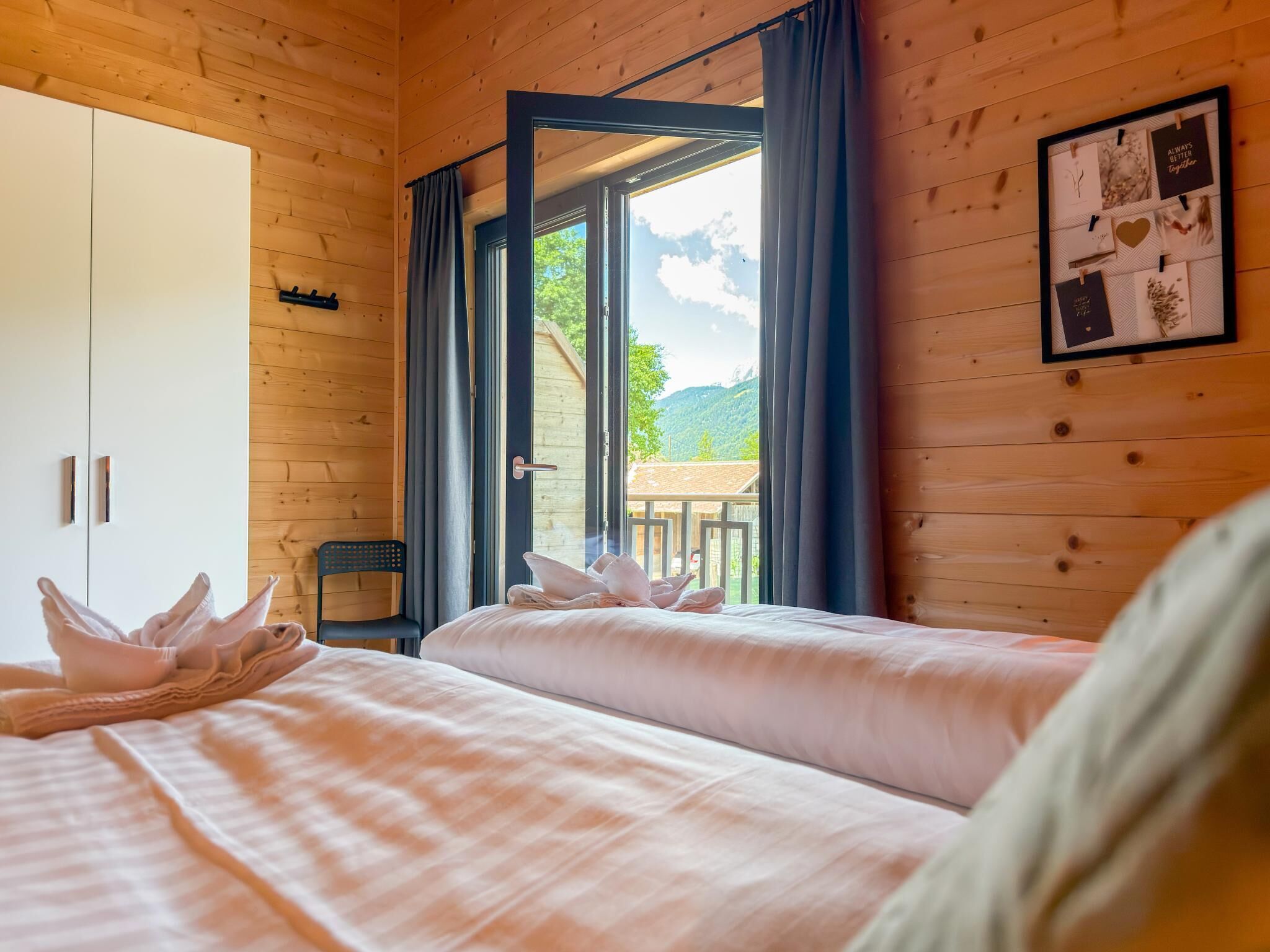 Una habitación de madera con una cama, una silla y un armario.