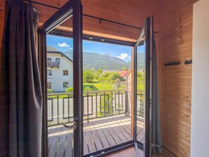 A wooden balcony with a view of a mountain and a building with a sign 'Bolihuis'. - Lovely holiday home on park near ski resort (Rattendorf)