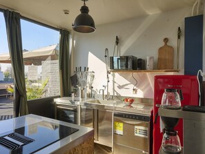 A compact kitchen with a built-in oven, a coffee machine, and a microwave on the countertop. - House in Kaag with rooftop terrace and spa bath. (Kaag)