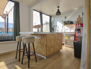 Eine moderne Küche mit einer Holzinsel, Barhocker und einer eingebauten Mikrowelle.