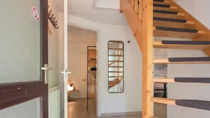 A staircase with wooden steps and a handrail, leading to an upper floor. - Detached lodge with pond view for 4 (Heesch)