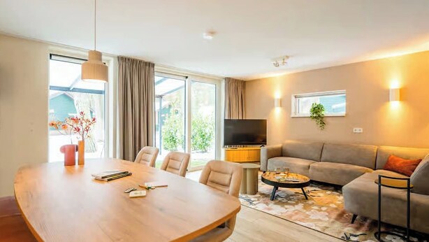 Ein modernes Wohnzimmer mit einem Holzespeisetisch, einer Couch und einem Fernseher.