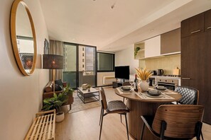 Eine moderne Küche mit Essbereich, Fernseher und Blick auf die Stadt.