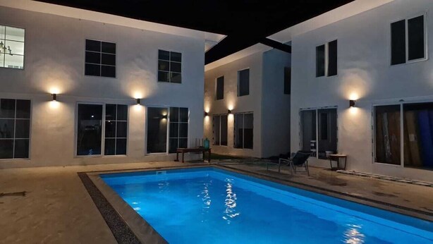 A swimming pool with a modern house in the background. - River view villas (Vang Vieng)