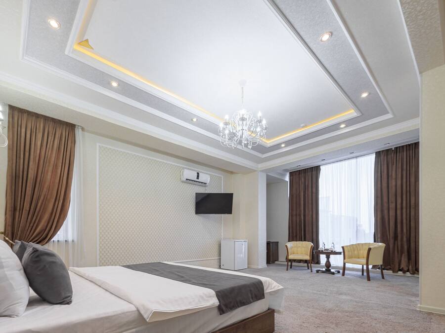 Una habitación de hotel con una cama, un televisor, un escritorio y una silla.