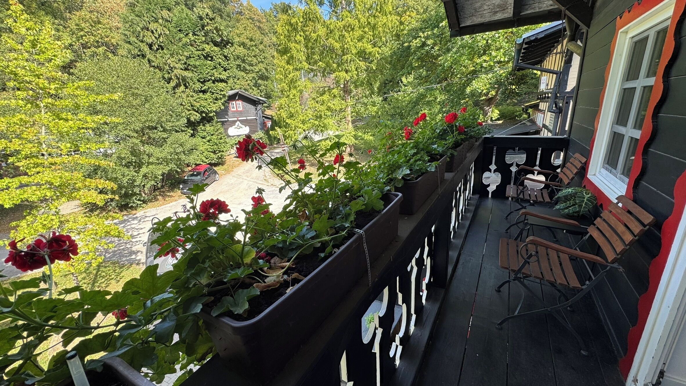 A balcony with potted plants and outdoor seating.