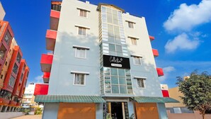 A multi-story hotel with a prominent sign, large windows, and a flat roof. - Classic With Balcony LR Residency (Anekal)