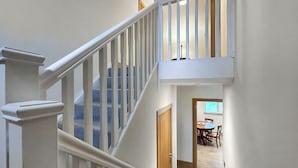 Eine Treppe mit weißen Geländern, die zu einer Zwischenebene führt.