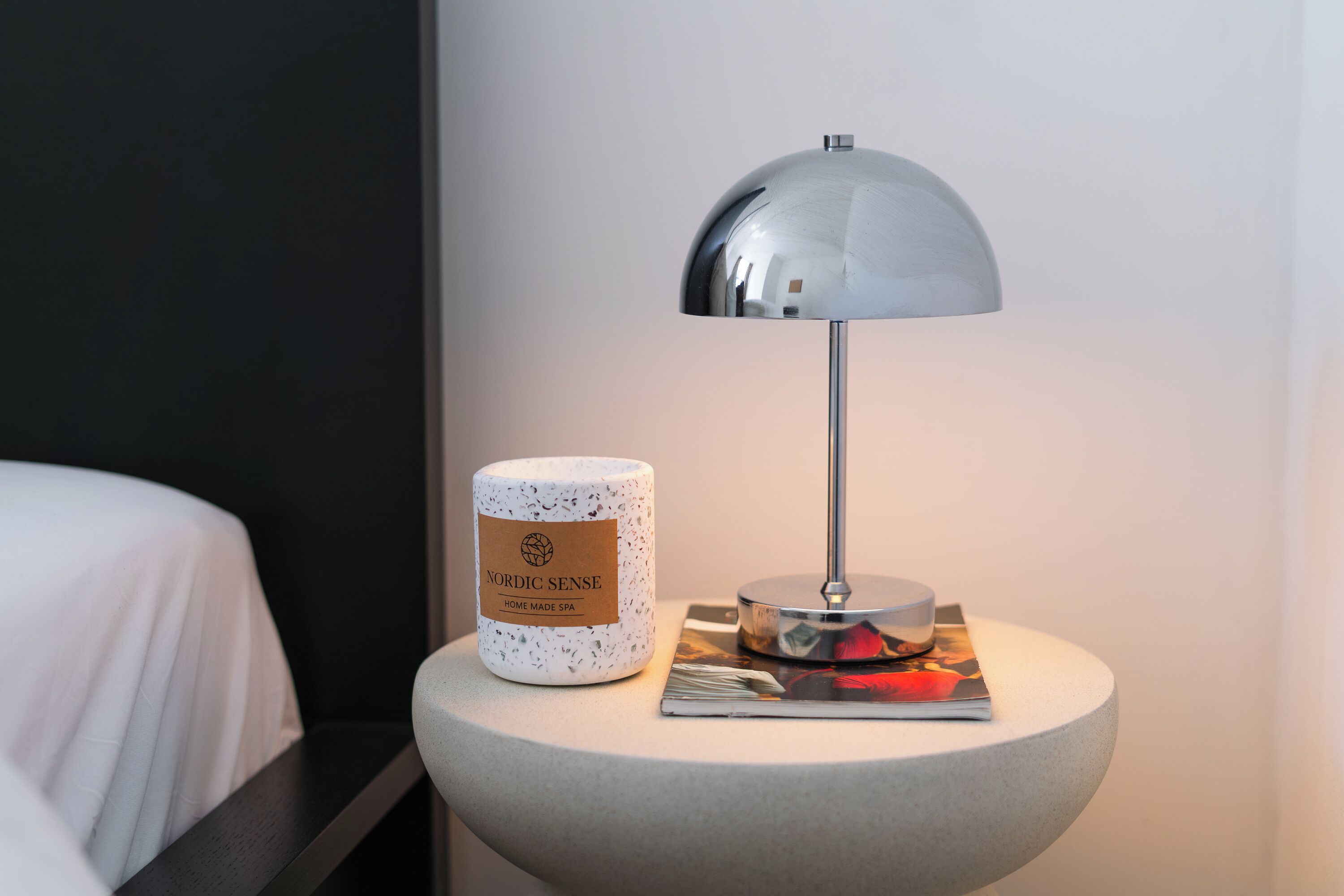Una mesa redonda con una lámpara y un recipiente con la etiqueta 'Nordic Sense Home Made Spa'.