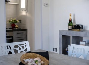 A modern kitchen with a dining area, a bottle of Moët & Chandon champagne, and a decorative bowl on the table. - Villa Aura del Salento con Giardino Privato, Wi-Fi e Aria Condizionata (Provincia di Lecce)
