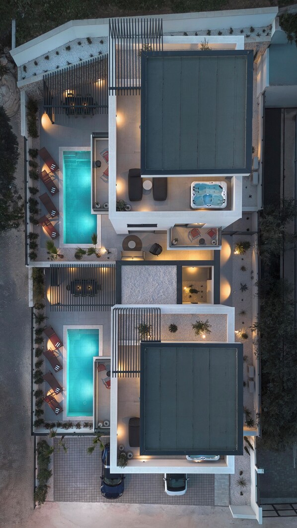 Una casa moderna con dos piscinas, mobiliario exterior y un jacuzzi.