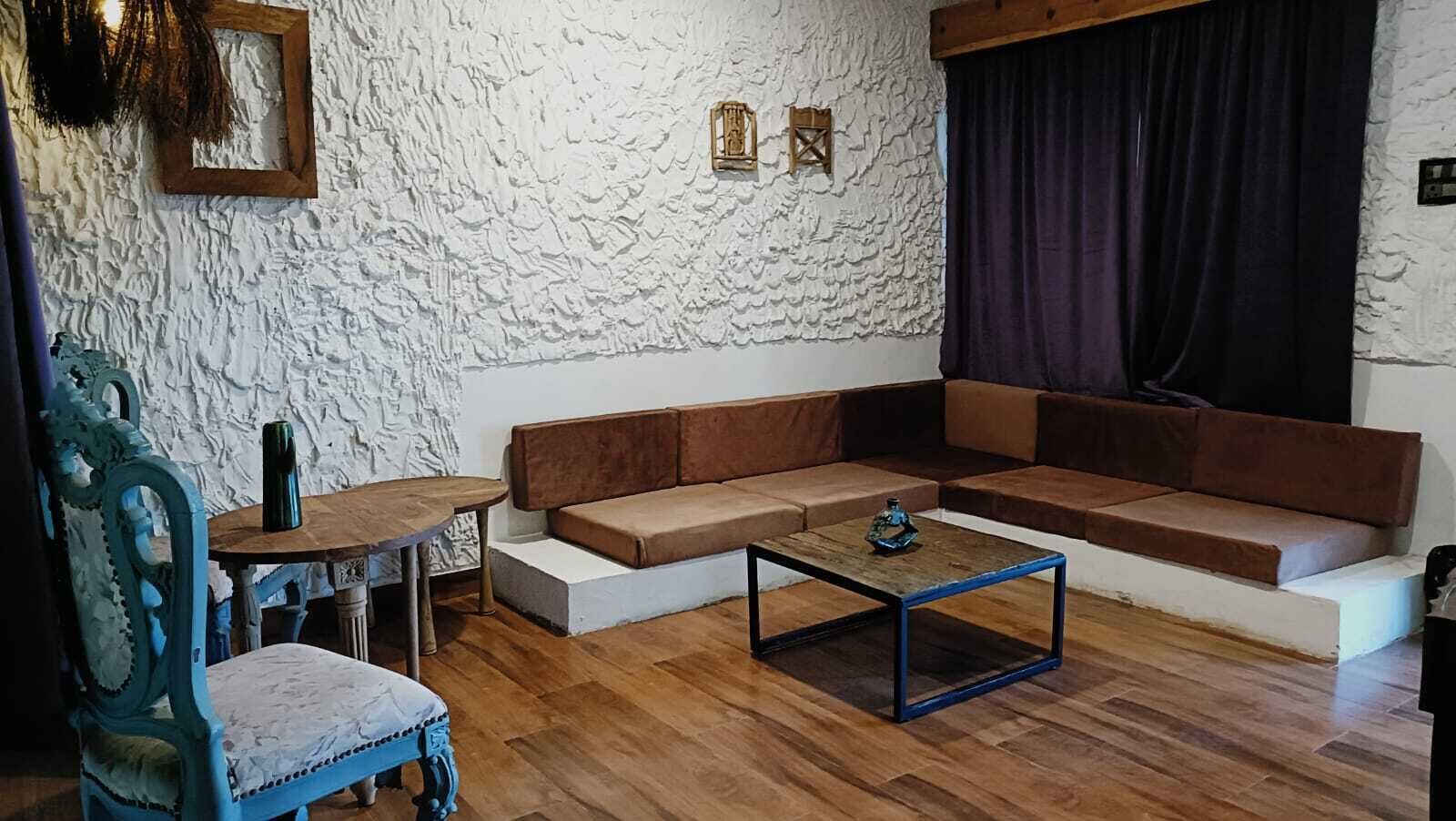 A living room with a sofa, a coffee table, a chair, and a textured wall.
