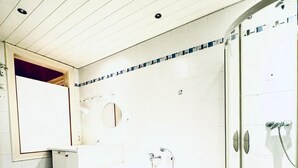 A bathroom with a white bathtub, a glass shower enclosure, and blue marble flooring. - Spacious Private Room Near FAC Platz (Wien)