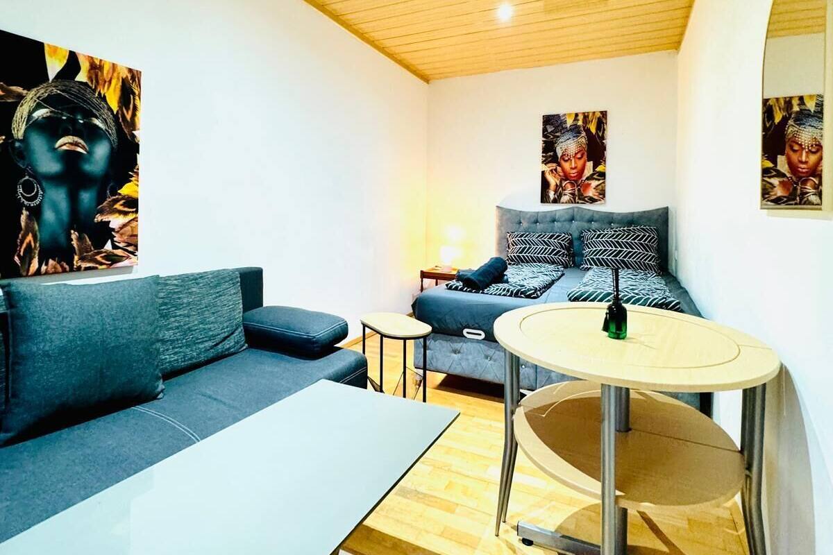 A modern living room with a sofa, a round table, and a lamp.