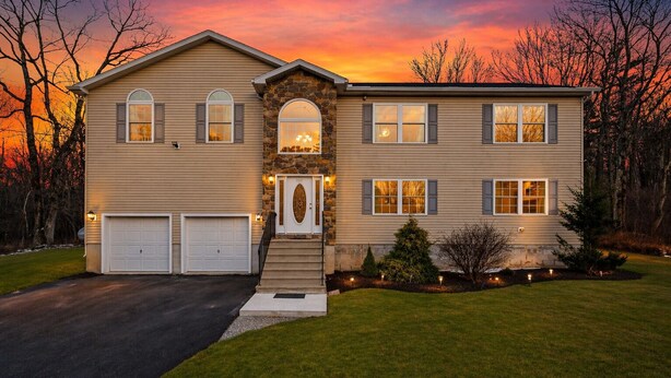 A two-story house with a stone entrance, two garages, and a well-maintained lawn. - Mount Pocono Escape • Firepit + Game Room • Near Trails + Lakes | Poconos Fun (Mount Pocono)