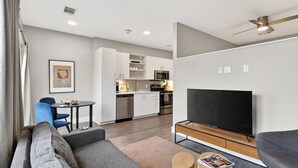 Un appartement moderne comprenant un salon, une cuisine et un coin repas.