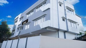A modern multi-story building with a flat roof, large windows, and a sign indicating it is a townhouse. - Super Townhouse Isbt Guwahati (Guwahati)