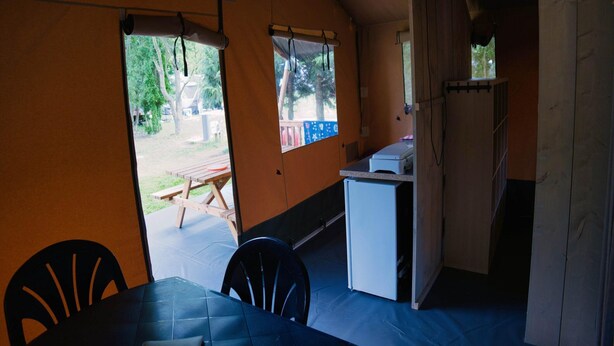 A room with a dining table, chairs, a small kitchenette, and a view of an outdoor area with a picnic table. - Getaway for 5 With Private Terrace (Janův Důl)