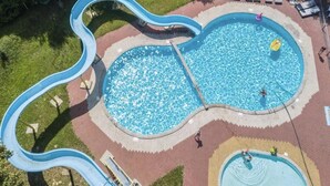 A swimming pool with a slide, surrounded by a brick walkway and lounge chairs. - Getaway for 5 With Private Terrace (Janův Důl)