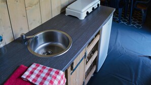 A compact kitchen with a sink, a portable stove, and a dining area with chairs. - Getaway for 5 With Private Terrace (Janův Důl)
